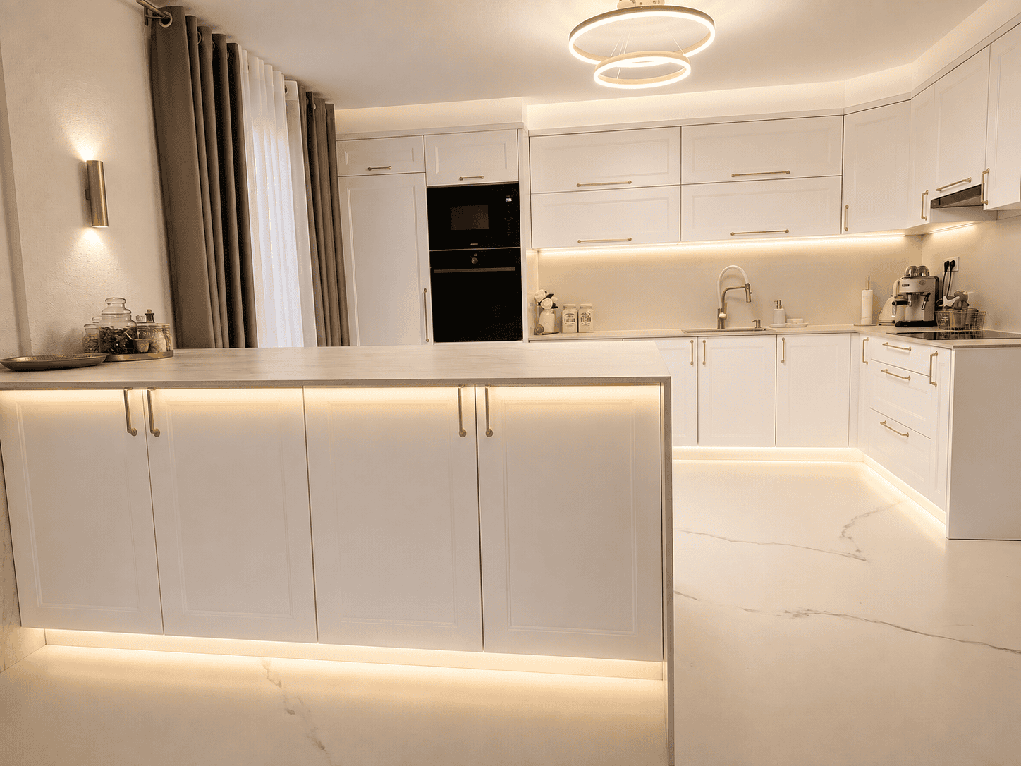 White kitchen with brass hardware and marble countertops